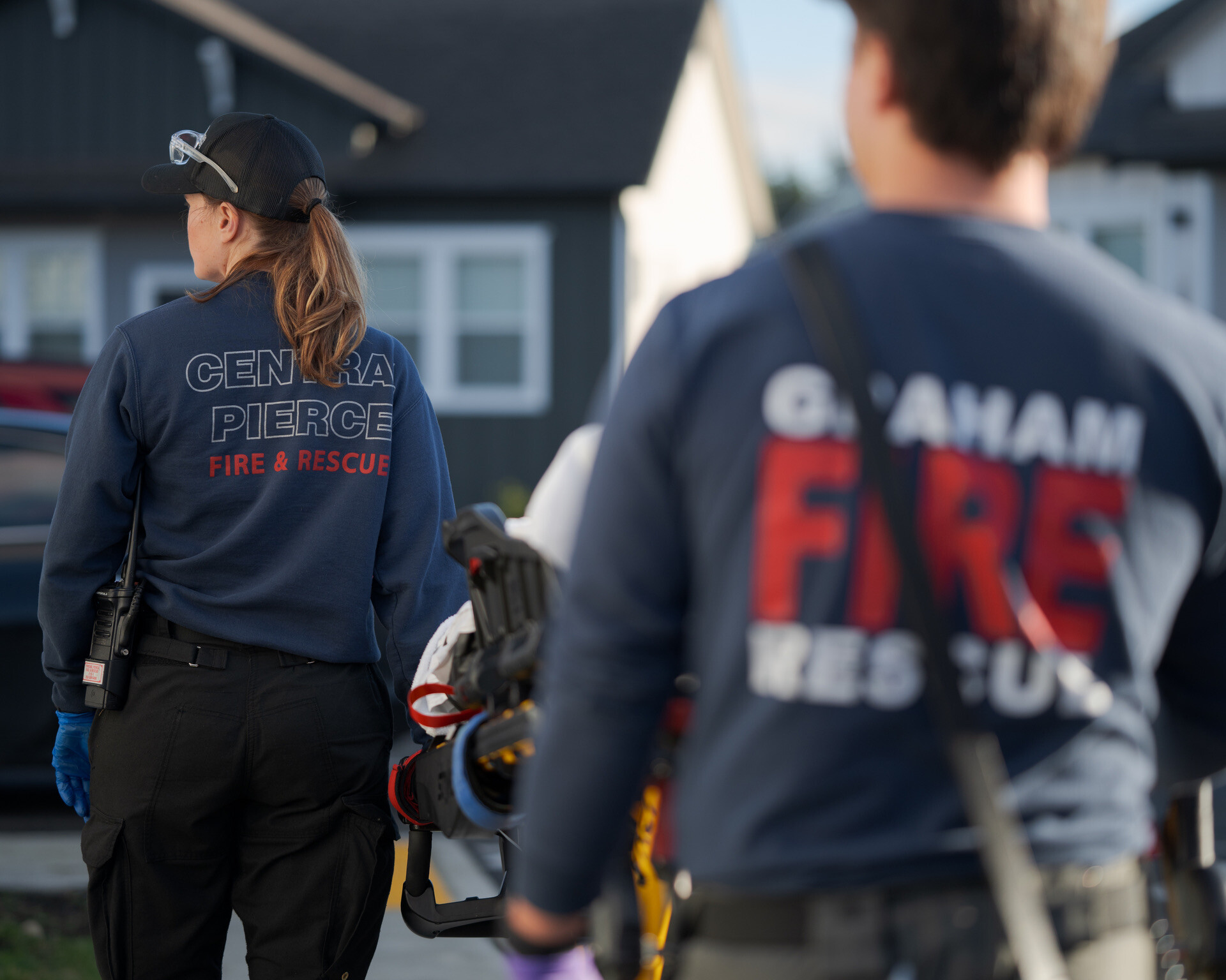Two firefighters in uniforms labeled 