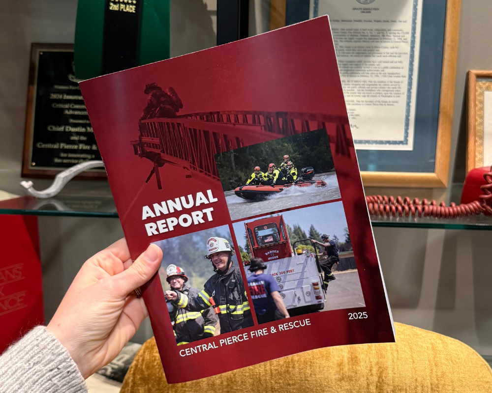 A hand holds a 2025 Central Pierce Fire & Rescue annual report with images of firefighters in action on the cover.